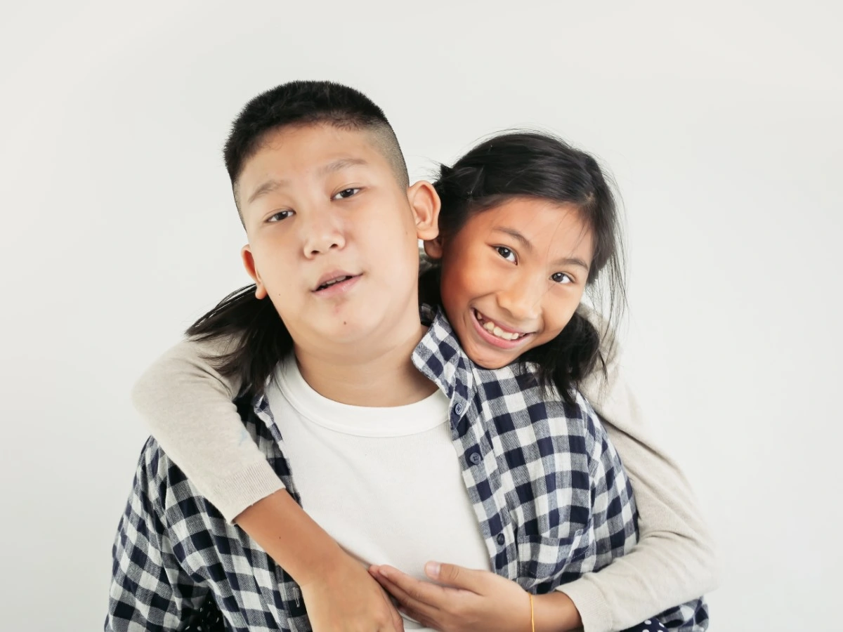 asian siblings hug